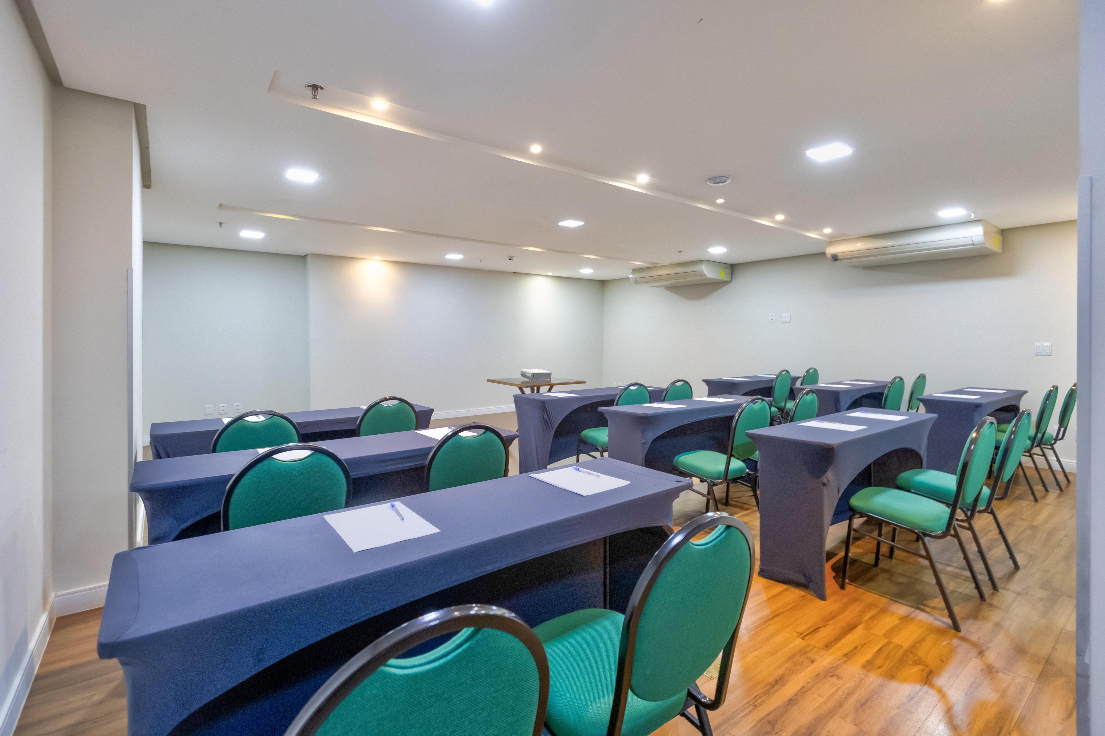 A conference room with tables, chairs, and ceiling lights.