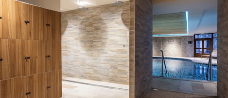 Un baño moderno con pared de piedra, un mueble de madera y zona de piscina.