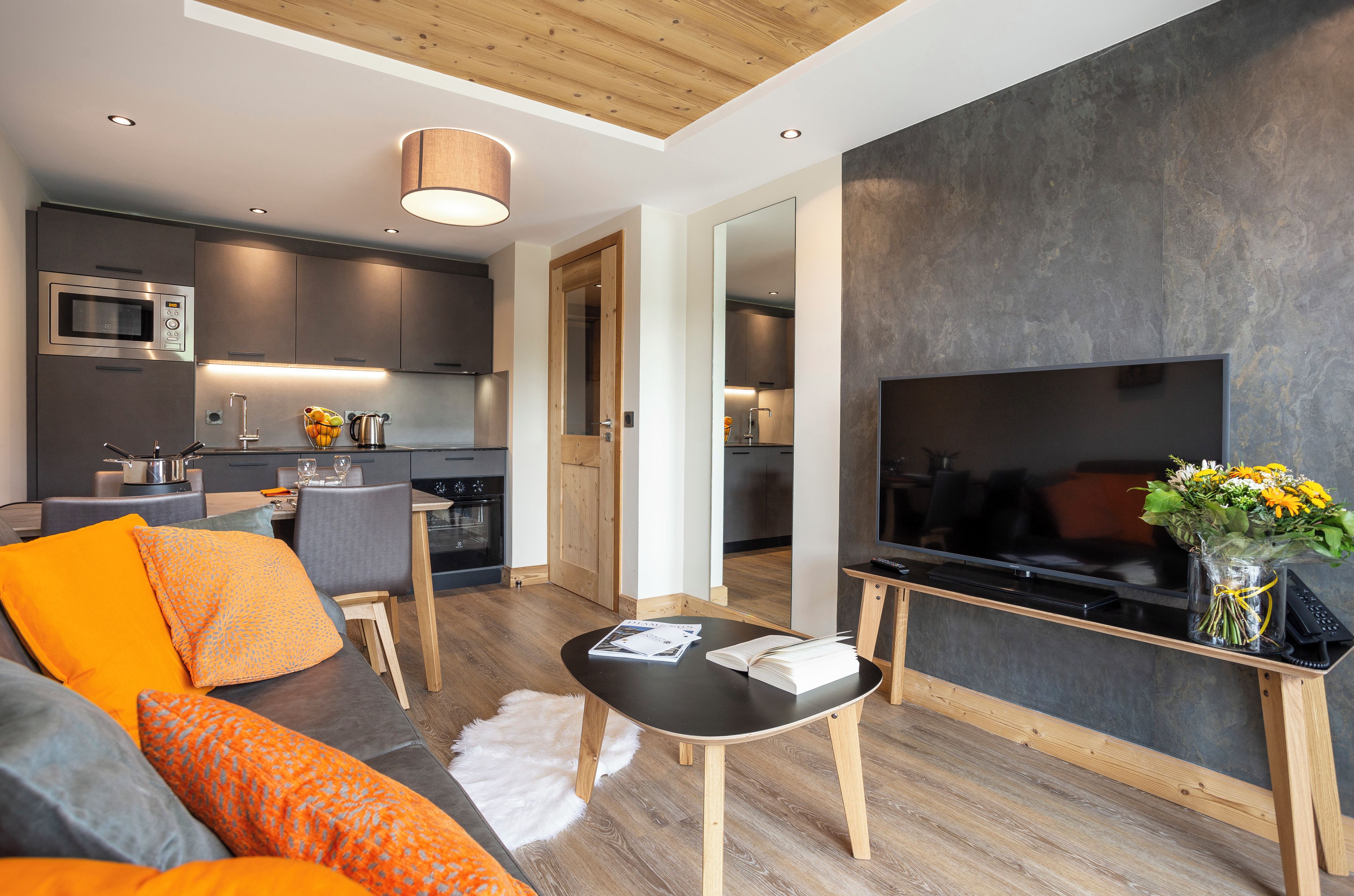A modern living room with a sofa, coffee table, and a flat-screen TV.