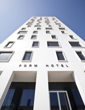 A modern hotel building with a white facade, multiple windows, and the name 'FORM HOTEL' displayed prominently. - Form Hotel Dubai (Dubai)