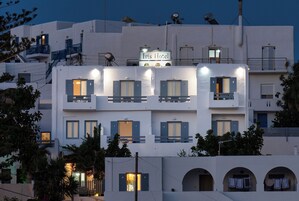 Un hotel con varios balcones, un letrero que dice "Iris Hotel" y varias ventanas con contraventanas.