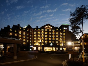 Ein mehrstöckiges Hotel mit Innenhof, beleuchteten Fenstern und einem sichtbaren Casinoschild.