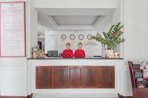 A hotel reception desk with a reception area, a reception sign, and a clock. - Praha Hotel Phu Quoc (Phu Quoc)