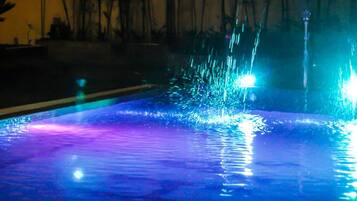 A pool with water jets and reflections.