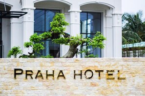 A stone wall with the text 'PRAHA HOTEL' and a bonsai tree in front. - Praha Hotel Phu Quoc (Phu Quoc)