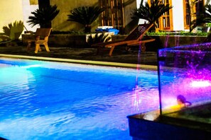 A swimming pool with lounge chairs and potted plants. - Praha Hotel Phu Quoc (Phu Quoc)