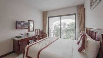 A hotel room with a bed, a desk, a chair, a television, and a large window with a view.