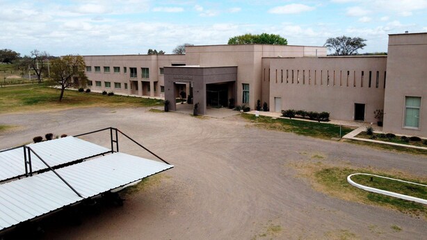 A building with a flat roof, a covered entrance, and a paved driveway.