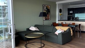 A modern living room with a sofa, coffee table, and a dining area with a table and chairs. - Location, location, location - as good as it gets in Napier (Napier)