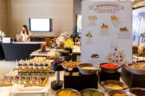 A buffet setup with various food categories and a sign detailing the mix and match granola options. - Intercontinental Fujairah Resort (FUJAIRAH)