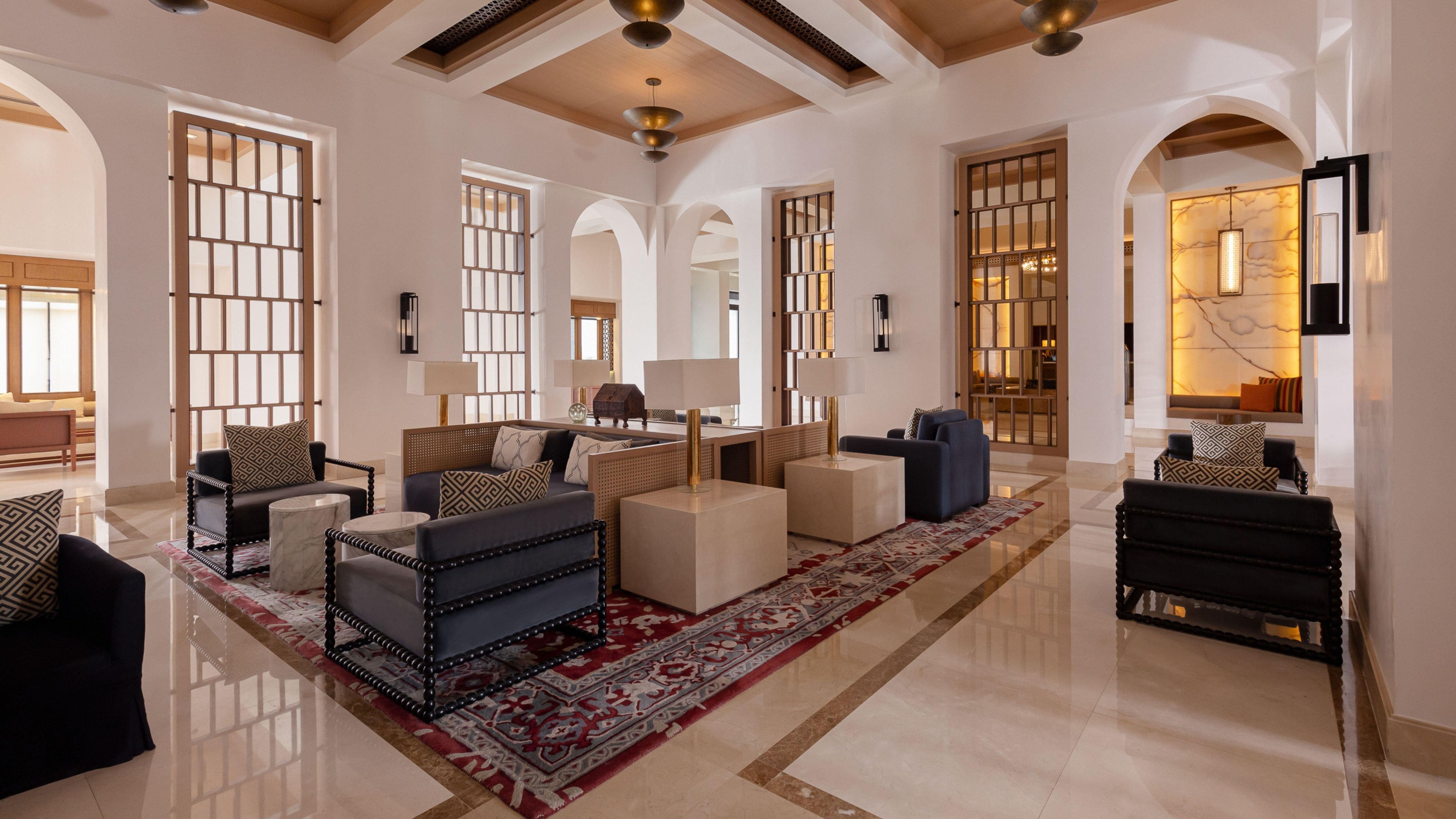 A spacious living area with modern furniture, a decorative rug, and a large window with a view.