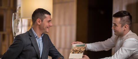 Due persone alla reception, una che consegna una brochure.