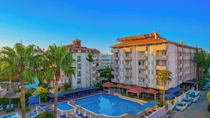Un hotel con piscina, varios balcones y vistas del entorno.