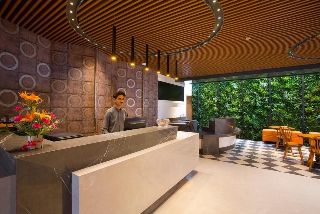 A modern reception area with a marble counter, a TV, and a seating area with a checkered floor.