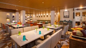 Un restaurante con varias mesas y cabinas, techo de madera y diversas decoraciones en las paredes.