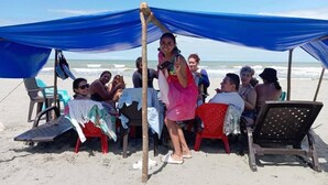 A beachside gathering with a blue canopy, beach chairs, and a table with a white tablecloth. - Cabaña Olas Del Mar (San Bernardo del Viento)