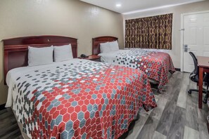 Two double beds with patterned bedding, a desk, and a chair in a hotel room. - Super 8 by Wyndham Waco North I-35 (Waco)