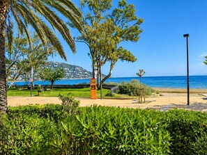 A coastal park with a paved walkway, benches, and a street lamp. - Apartment next to the Beach in Roses, Costa Brava! 2 Bedrooms, Sea Views, Free Wi-Fi. Book now! (Roses)