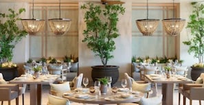 Un restaurante con mesas redondas, candelabros y plantas en macetas.