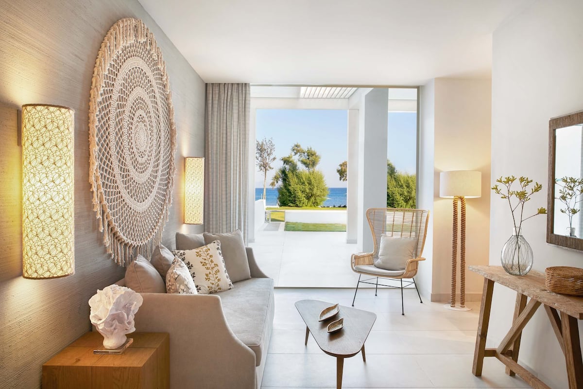 Una sala de estar moderna con un sofá, una mesa de centro, arte decorativo en la pared y vistas al exterior.