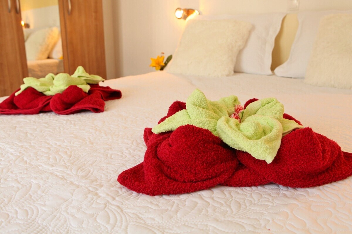 Ein Hotelzimmer mit einem ordentlich bezogenen Bett, einem Spiegel und einer Wandleuchte.