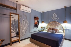 Un dormitorio con una cama, una silla colgante y un aire acondicionado instalado en la pared.