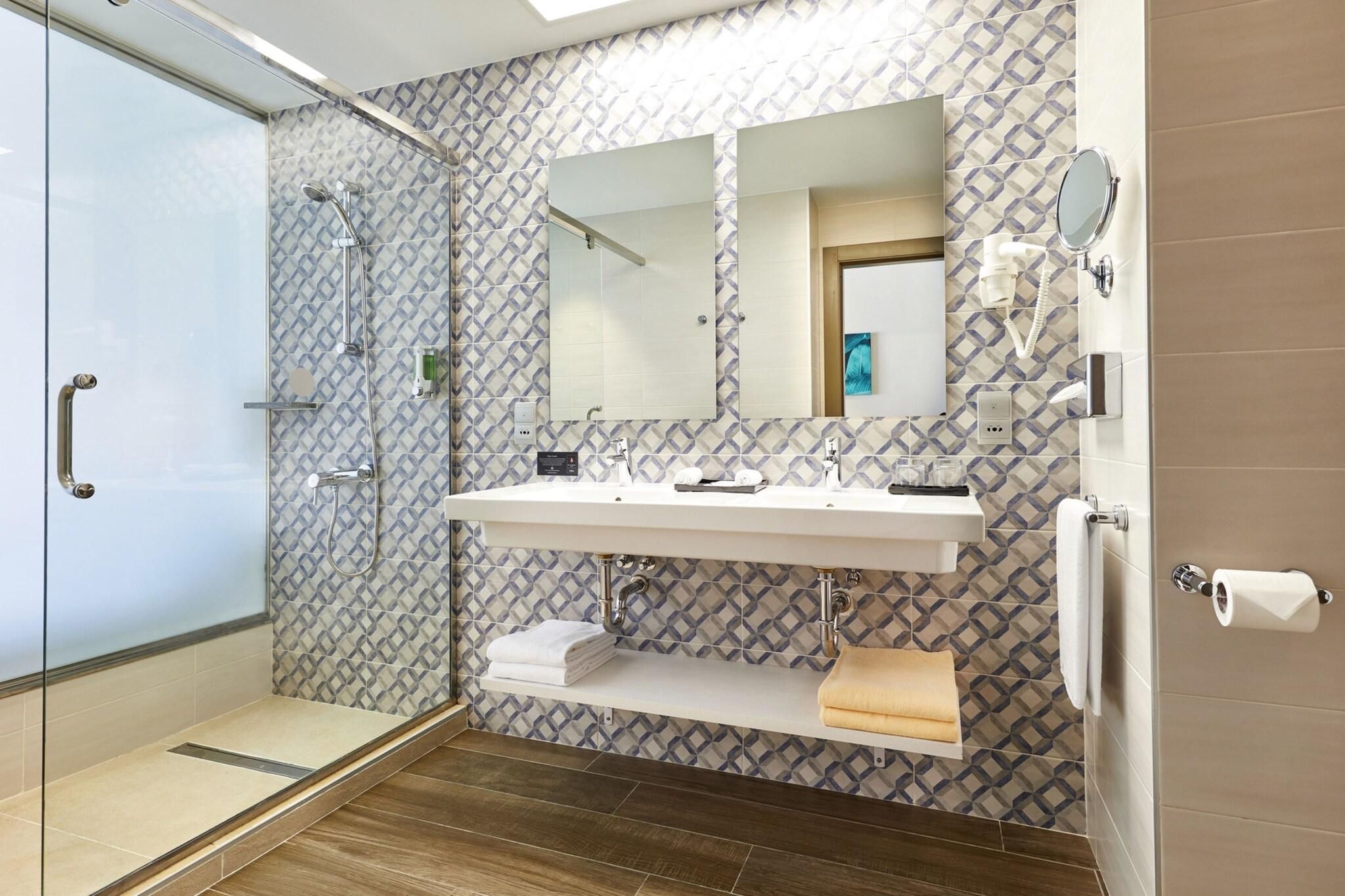 A modern bathroom with a glass shower enclosure, a vanity with a mirror, and a toilet.