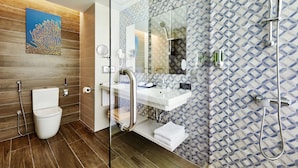 A modern bathroom with a glass shower enclosure, a white sink, and a wooden vanity.