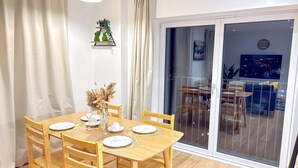 A dining area with a wooden table, chairs, and a vase of dried flowers. - City Centre - Apt - Sleeps4 - Canal View - Parking (West Midlands)