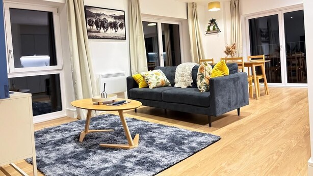 A modern living room with a sofa, coffee table, and dining area. - City Centre - Apt - Sleeps4 - Canal View - Parking (West Midlands)