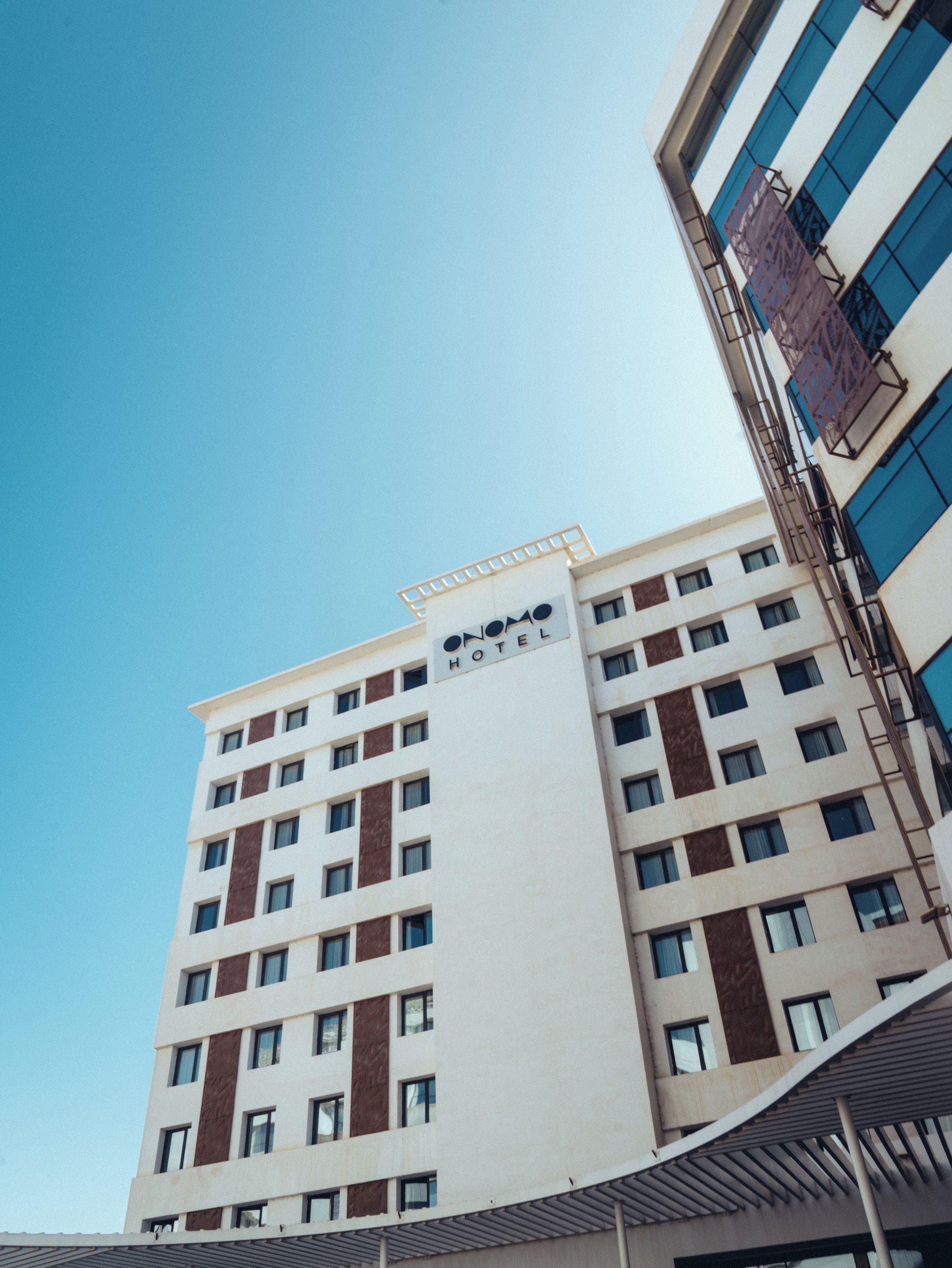 Un hotel de varios pisos con un letrero llamativo que dice 'HOTEL' en la fachada.