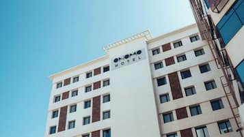 Un hotel de varios pisos con un letrero llamativo que dice 'HOTEL' en la fachada.