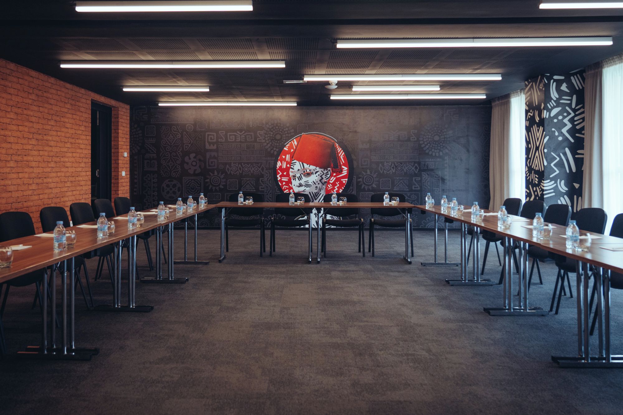 A conference room with a long table, chairs, and water bottles.