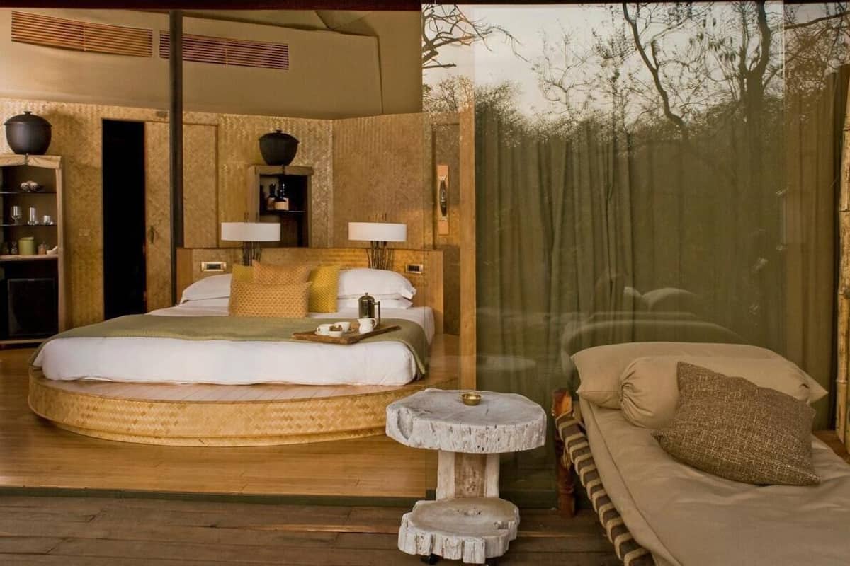 Ein Zimmer mit einem großen Bett, Nachttischen und Blick durch ein Fenster.
