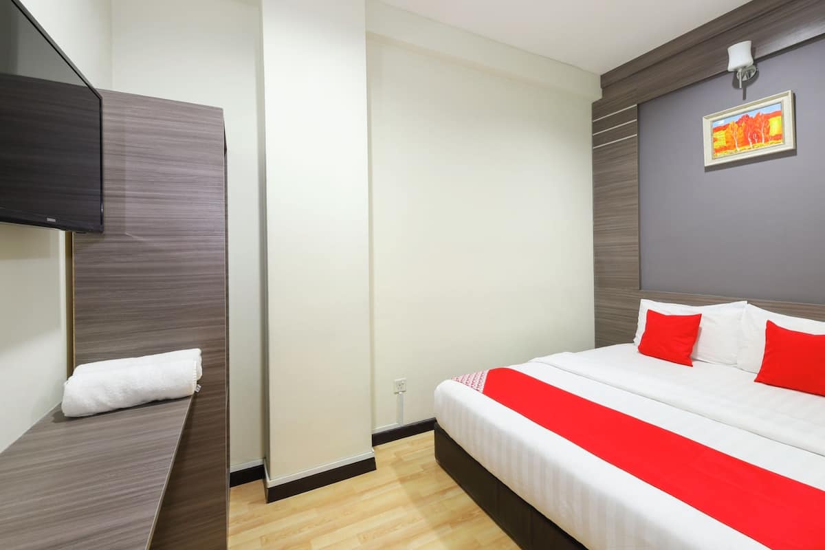 Ein modernes Hotelzimmer mit einem Bett, einem Flachbildfernseher und einem Gemälde an der Wand.