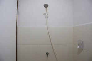 A shower with a handheld showerhead and a wall-mounted faucet. - Reddoorz Apartment @ Green Lake View Ciputat (Jakarta)