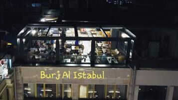 Ein Gebäude mit einem Schild, auf dem 'Burj Al Istabul' steht, und einer Glasfassade.