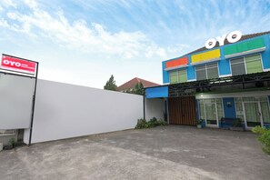 A building with a colorful facade, a sign reading 'OYO', and a guest house entrance. - Hotel Padjadjaran 1 (Depok)