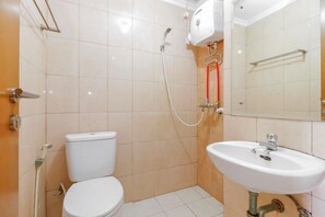 A bathroom with a toilet, a sink, and a shower with a handheld showerhead. - Reddoorz Apartment @ Margonda Residence Tower 2 (Depok)