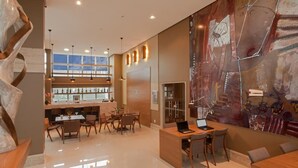 A modern interior with a bar area, seating, and a large abstract mural. - Jade Hotel (Guará)