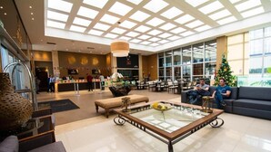 Eine Hotellobby mit Glastisch, Sitzecke und Rezeption.