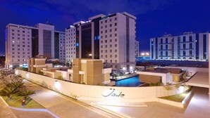 A modern hotel complex with multiple high-rise buildings, a swimming pool, and a landscaped area with palm trees. - Jade Hotel (Guará)