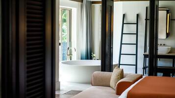 A modern bathroom with a bathtub, a mirror, and a sink.