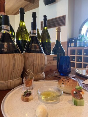 A table with wine bottles, a blue glass, and food items.