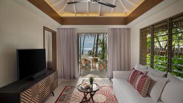 A modern living room with a TV, sofa, and a ceiling fan.