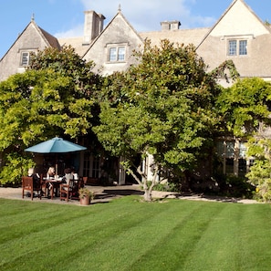 A large stone building with a garden patio area. - The Greenway (Cheltenham)