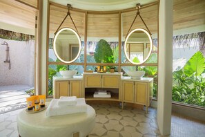 Un baño con un espejo grande, armarios de madera y una bañera.