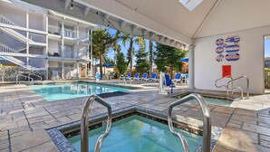 A pool area with multiple pools, lounge chairs, and a covered section with a view of the building's exterior. - Spacious Accessible 2BR Suite | King + 2 Queens | Santa Cruz (Santa Cruz)