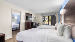 A hotel room with two beds, a desk, a TV, and a view of the outside. - Spacious Accessible 2BR Suite | King + 2 Queens | Santa Cruz (Santa Cruz)