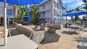A hotel with outdoor seating, umbrellas, and a pool area. - Spacious Accessible 2BR Suite | King + 2 Queens | Santa Cruz (Santa Cruz)